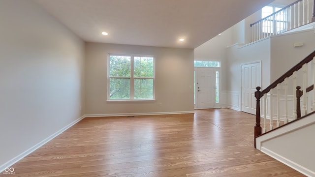 entryway with a high ceiling and light hardwood / wood-style flooring