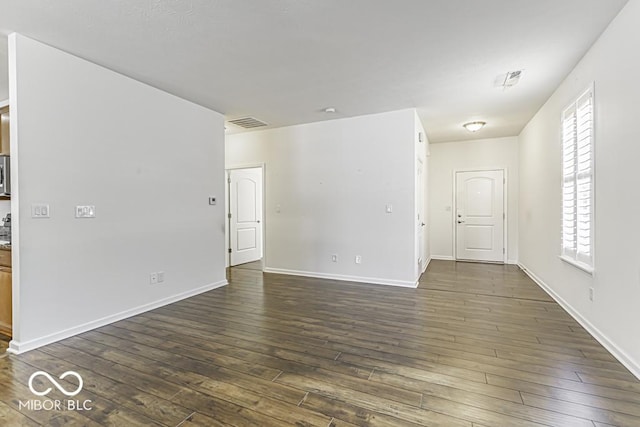 unfurnished room with a healthy amount of sunlight and dark hardwood / wood-style flooring