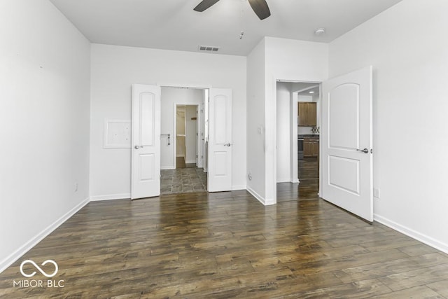 unfurnished bedroom with ceiling fan and dark hardwood / wood-style floors