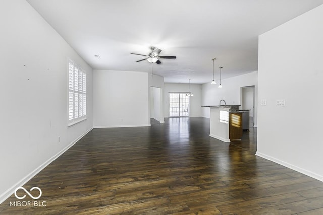 unfurnished living room with ceiling fan and dark hardwood / wood-style floors