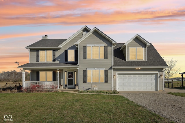 view of front facade featuring a yard, a garage, and a porch