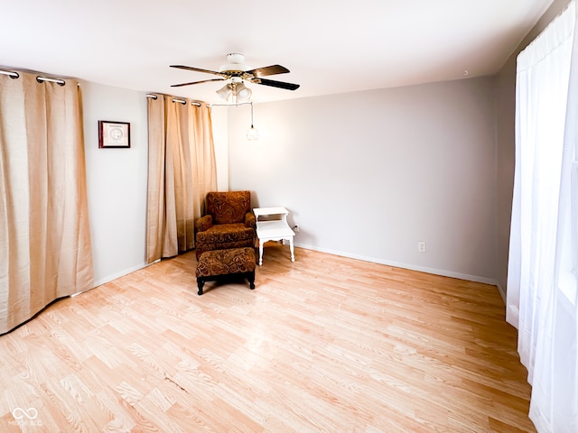 living area with ceiling fan and light hardwood / wood-style floors