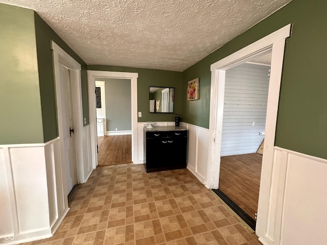 hall featuring a textured ceiling