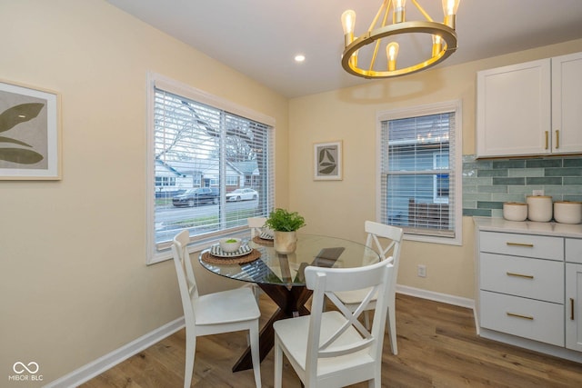 dining area with dark hardwood / wood-style floors and an inviting chandelier