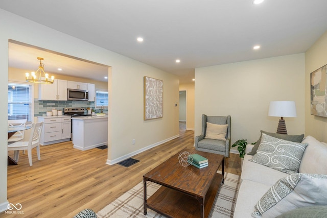 living room featuring a notable chandelier and light hardwood / wood-style flooring