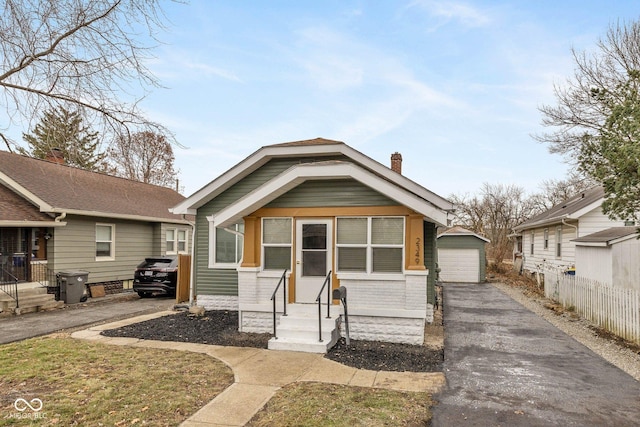 bungalow-style house with a garage and an outbuilding