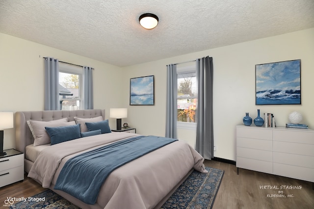 bedroom featuring wood-type flooring, a textured ceiling, and multiple windows