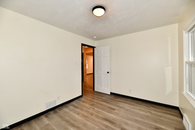 empty room with light wood-type flooring and a wealth of natural light