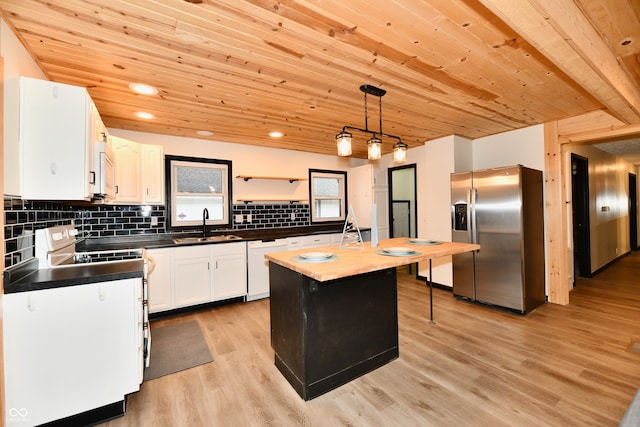 kitchen featuring sink, hanging light fixtures, light hardwood / wood-style floors, white appliances, and a kitchen island