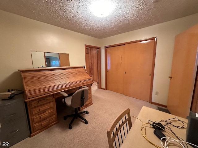 carpeted office space featuring a textured ceiling