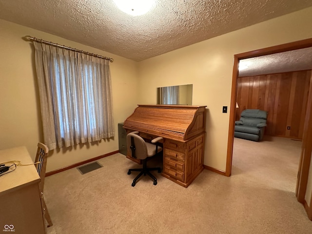 carpeted home office featuring a textured ceiling