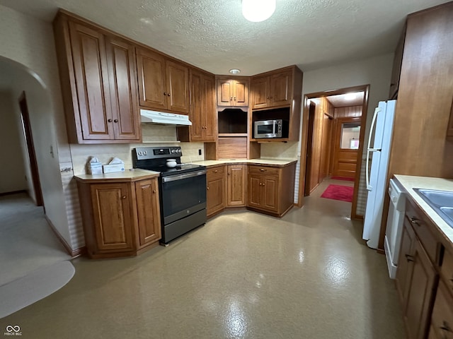 kitchen with backsplash, a textured ceiling, and appliances with stainless steel finishes