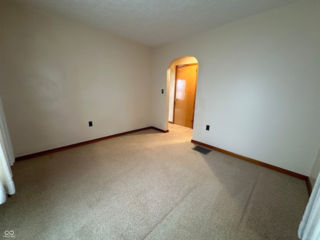 spare room featuring carpet floors and a textured ceiling