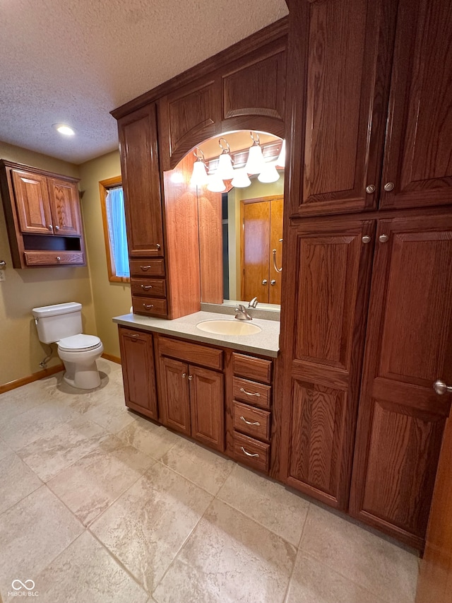 bathroom with tile patterned floors, vanity, a textured ceiling, and toilet