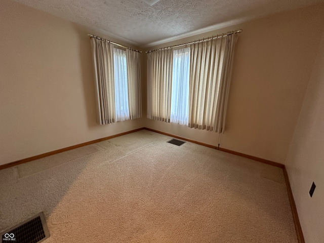 empty room featuring carpet and a textured ceiling