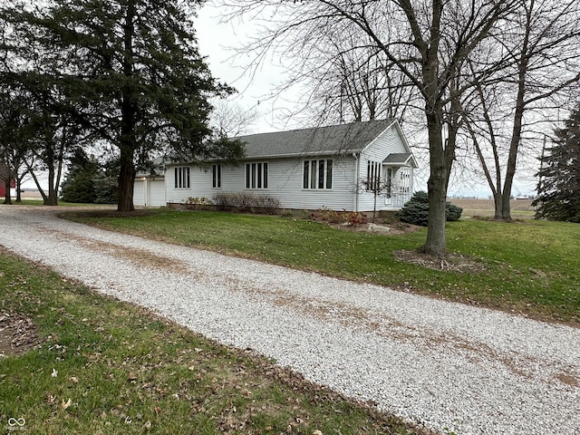 ranch-style home with a garage, a front lawn, and an outdoor structure