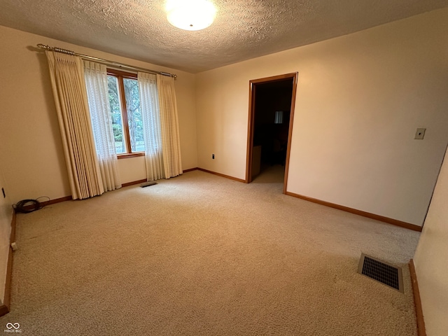 empty room with carpet and a textured ceiling