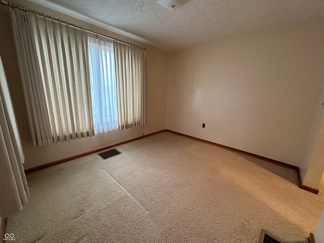 carpeted empty room with a textured ceiling