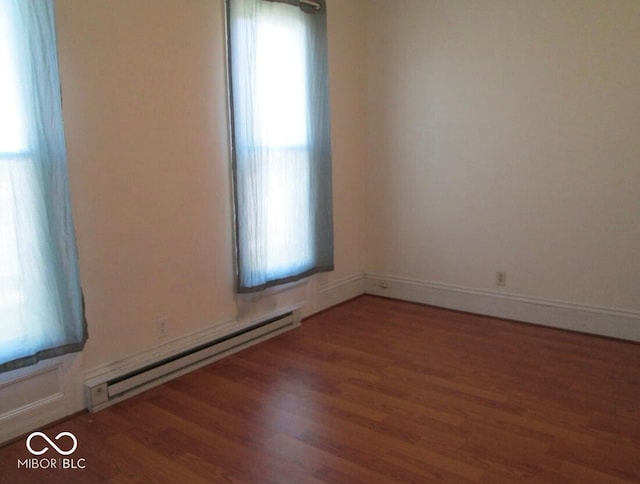 spare room featuring dark hardwood / wood-style floors and a baseboard heating unit