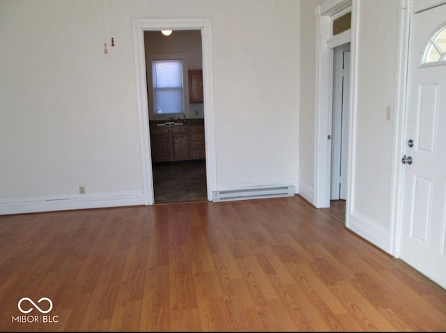 entryway featuring sink, a baseboard radiator, and hardwood / wood-style flooring