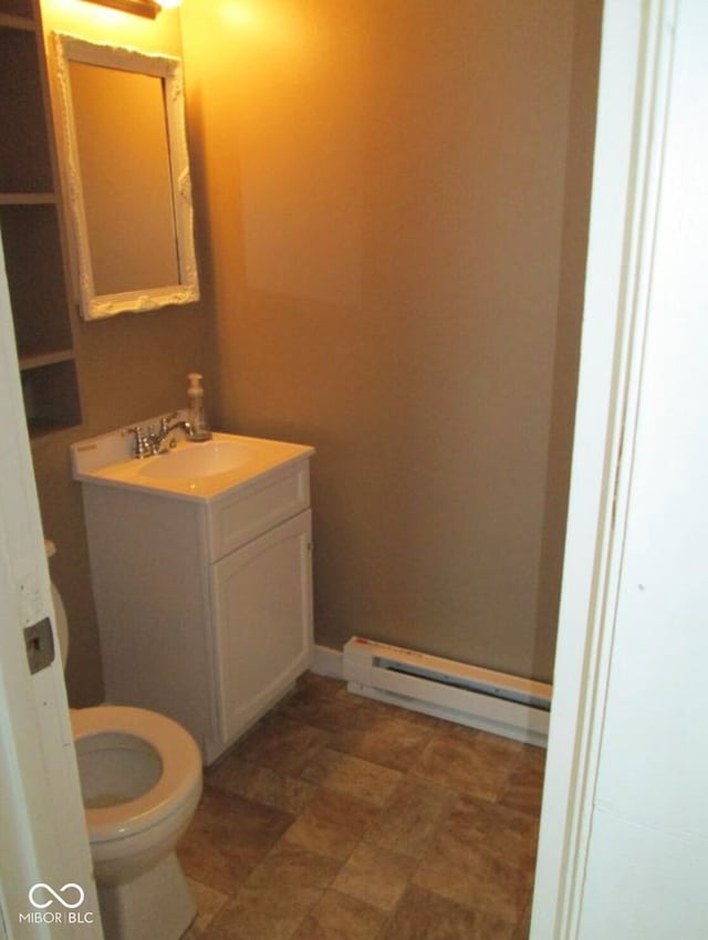 bathroom featuring vanity, toilet, and baseboard heating