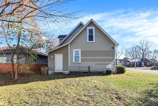 rear view of house with a lawn and cooling unit