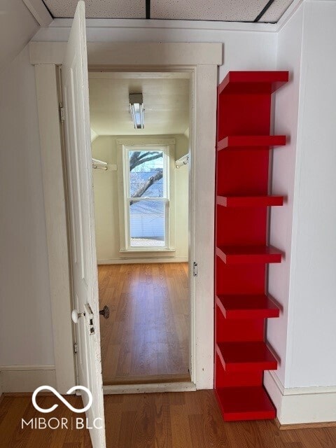 hallway featuring lofted ceiling and hardwood / wood-style flooring