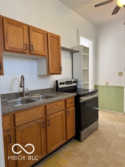 kitchen featuring ceiling fan, electric stove, and sink