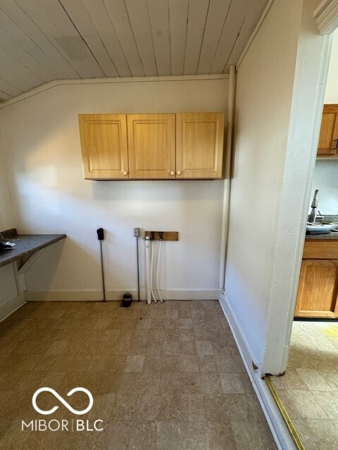 washroom with cabinets, wood ceiling, and sink