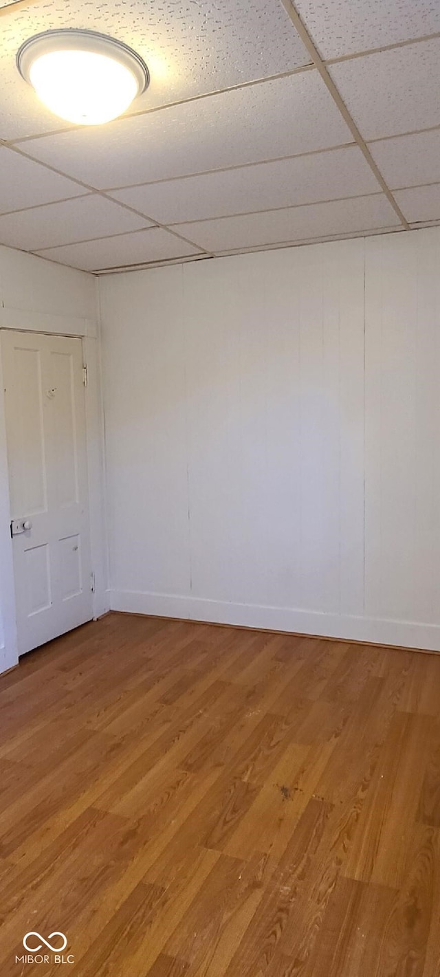 empty room with hardwood / wood-style floors and a paneled ceiling