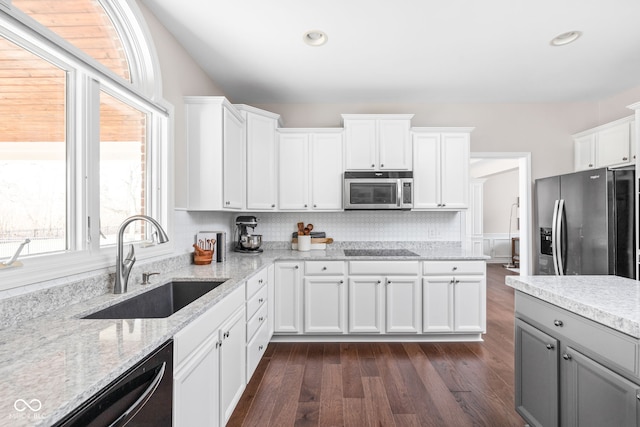 kitchen featuring black appliances, sink, a wealth of natural light, dark hardwood / wood-style flooring, and white cabinetry