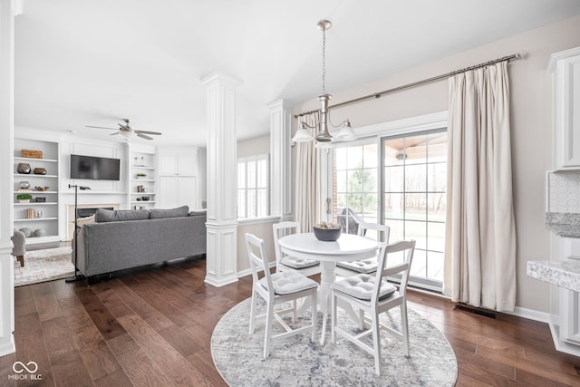 dining room with dark hardwood / wood-style flooring, decorative columns, and ceiling fan