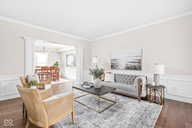 living room with decorative columns, dark wood-type flooring, and a notable chandelier