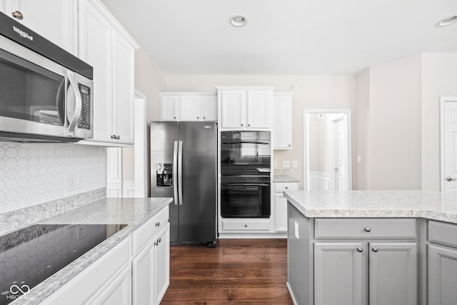 kitchen featuring white cabinets, backsplash, dark hardwood / wood-style floors, and black appliances