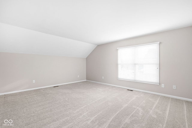 bonus room featuring light carpet and vaulted ceiling