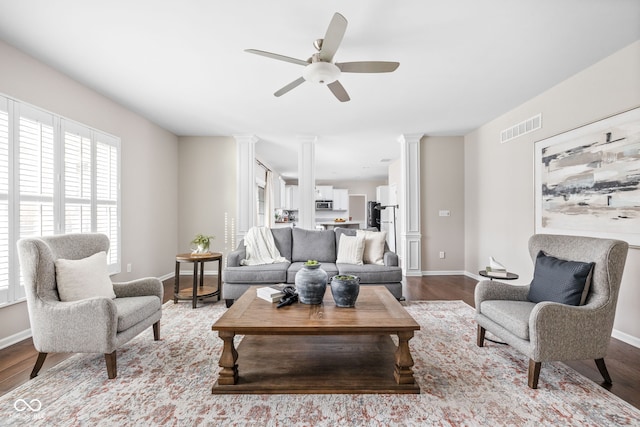 living room featuring light hardwood / wood-style flooring, ceiling fan, and ornate columns