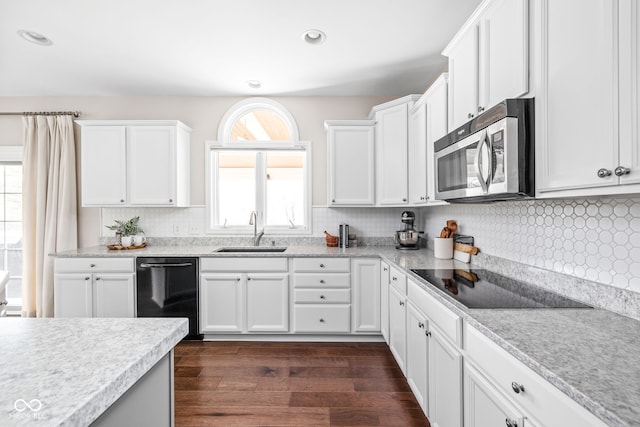 kitchen with dark wood-type flooring, sink, white cabinets, and black appliances