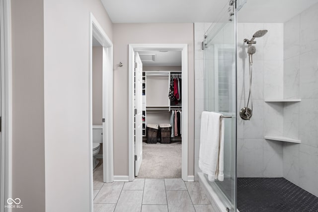 bathroom with tile patterned floors, toilet, and an enclosed shower