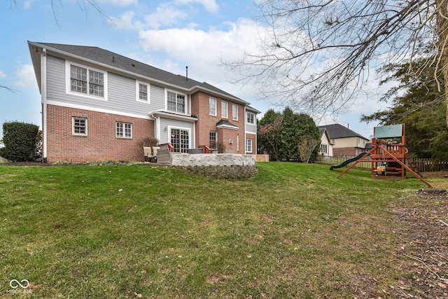 rear view of house with a playground and a lawn