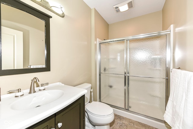 bathroom featuring vanity, an enclosed shower, and toilet