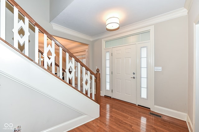 foyer with hardwood / wood-style floors and crown molding