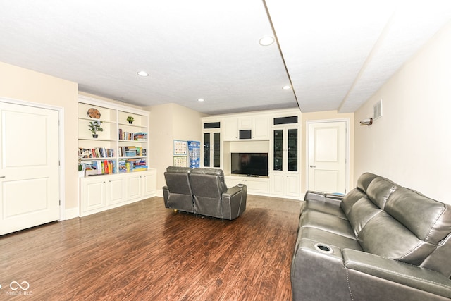 living room featuring dark hardwood / wood-style flooring and a textured ceiling