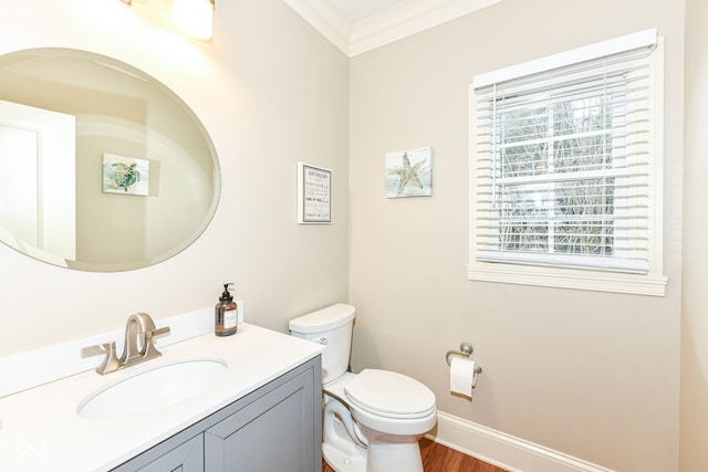 bathroom with ornamental molding, vanity, toilet, and a healthy amount of sunlight