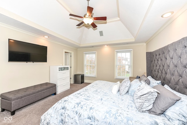 carpeted bedroom with ceiling fan, ornamental molding, and a tray ceiling