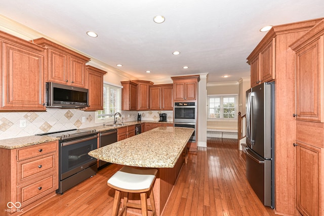 kitchen with a center island, stainless steel appliances, plenty of natural light, and light hardwood / wood-style floors