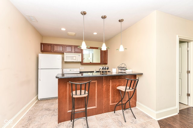 kitchen with a breakfast bar, white appliances, decorative light fixtures, light hardwood / wood-style floors, and kitchen peninsula