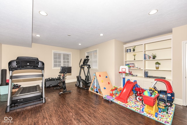 workout area with dark hardwood / wood-style floors and a textured ceiling