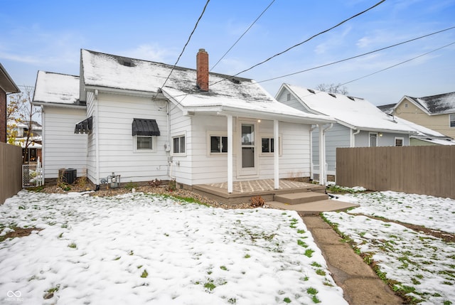 snow covered rear of property with a deck