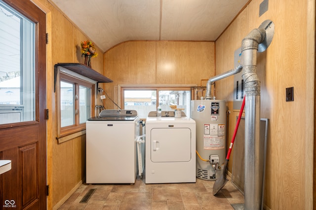 washroom featuring independent washer and dryer, wooden walls, and water heater