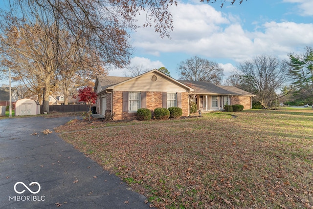 ranch-style house with a front yard and a storage shed